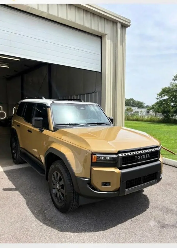 Gold Toyota Land Cruiser outside the Coast 2 City shop