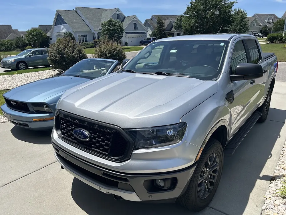 Silver Ford Ranger and blue Ford Mustang convertible photographed by Ed Reeve in his Google review
