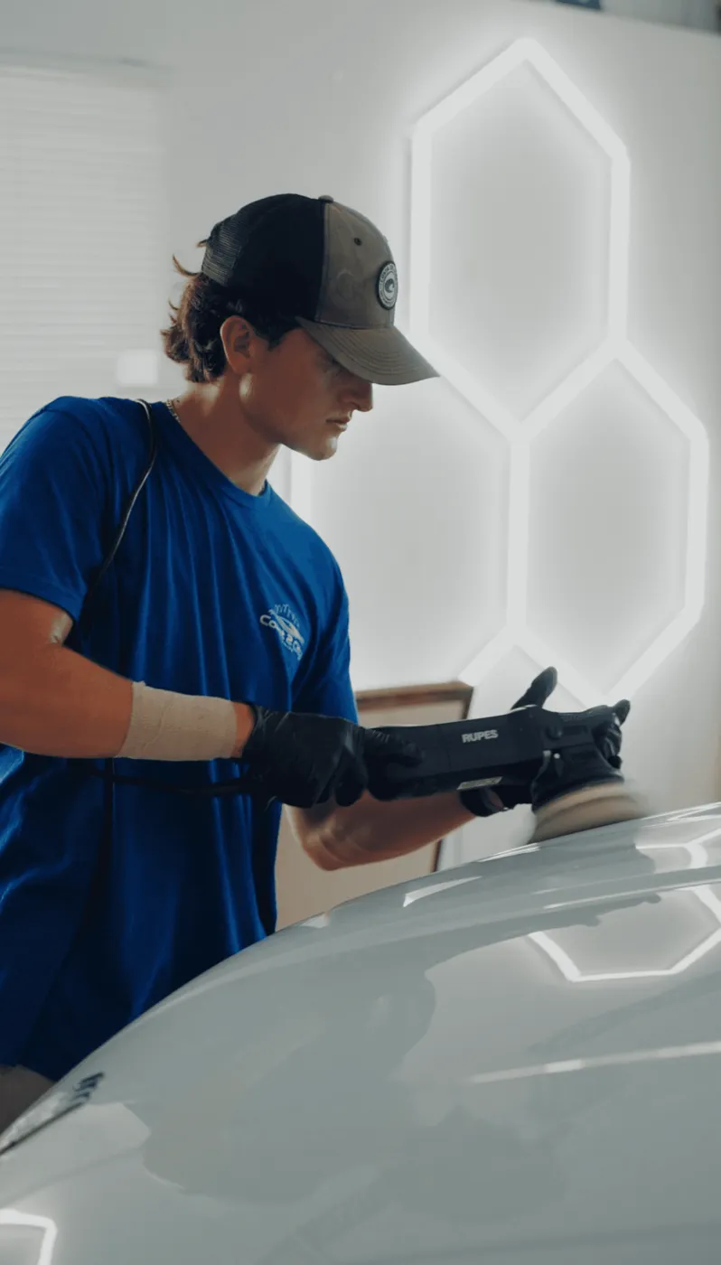 Coast 2 City detailer polishing paint under hexagon shop lights